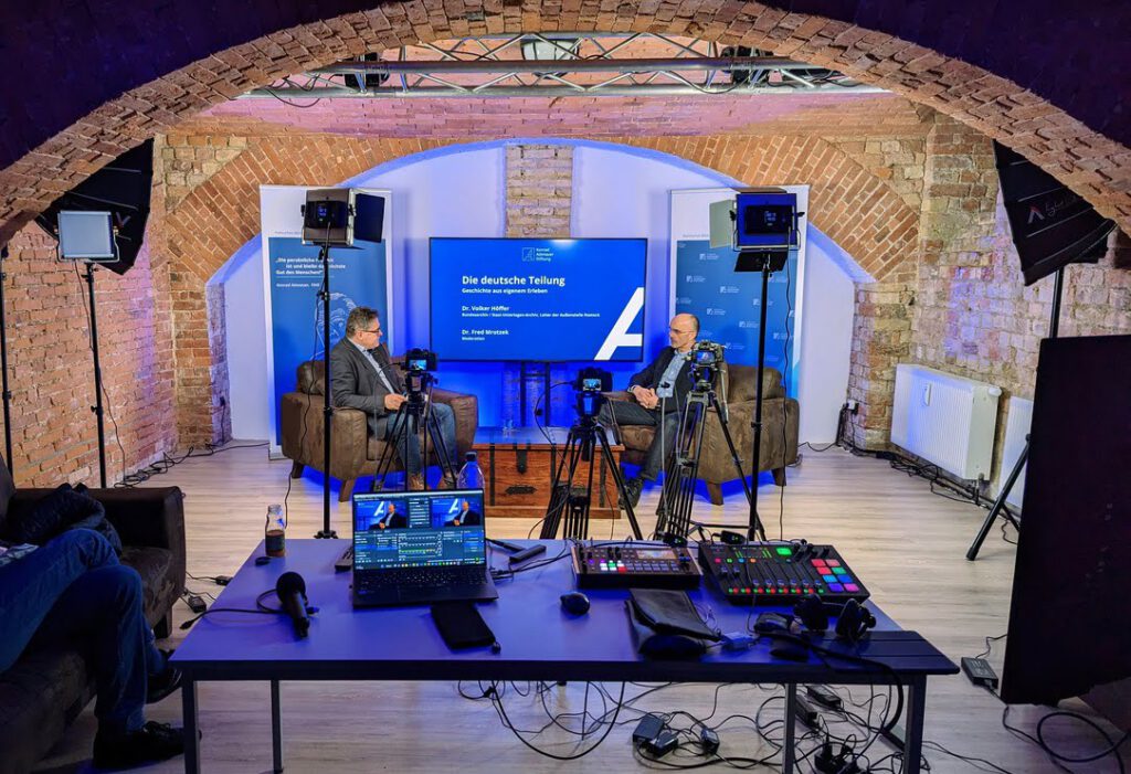Zwei Personen während einer live Diskussionsrunde im TMPL Studio.